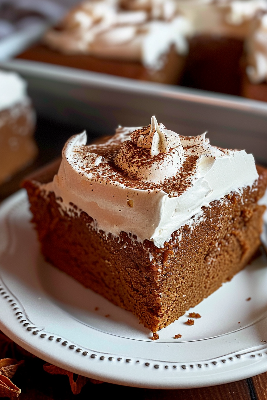 A thick slice of gingerbread cake featuring creamy whipped topping and festive garnish.