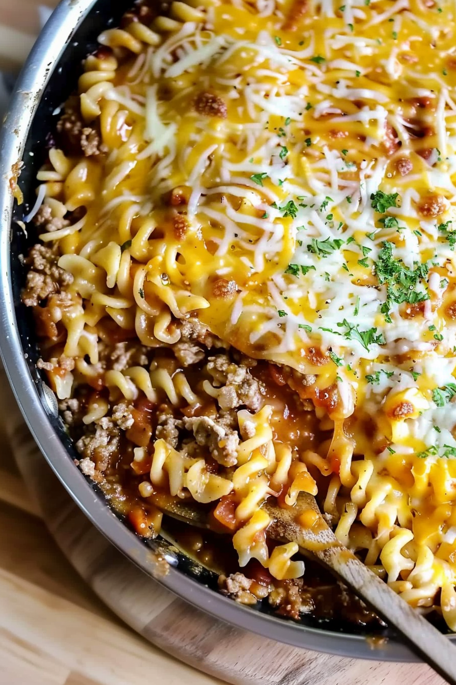 A hearty skillet meal featuring tender pasta coated in a rich, meaty tomato sauce and melted cheese.