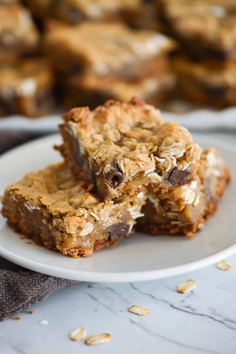 A plate showcasing thick oatmeal bars with a crumbly texture and chocolate chips.