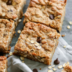 A stack of chewy oatmeal cookie bars with chocolate chips and oats visible.