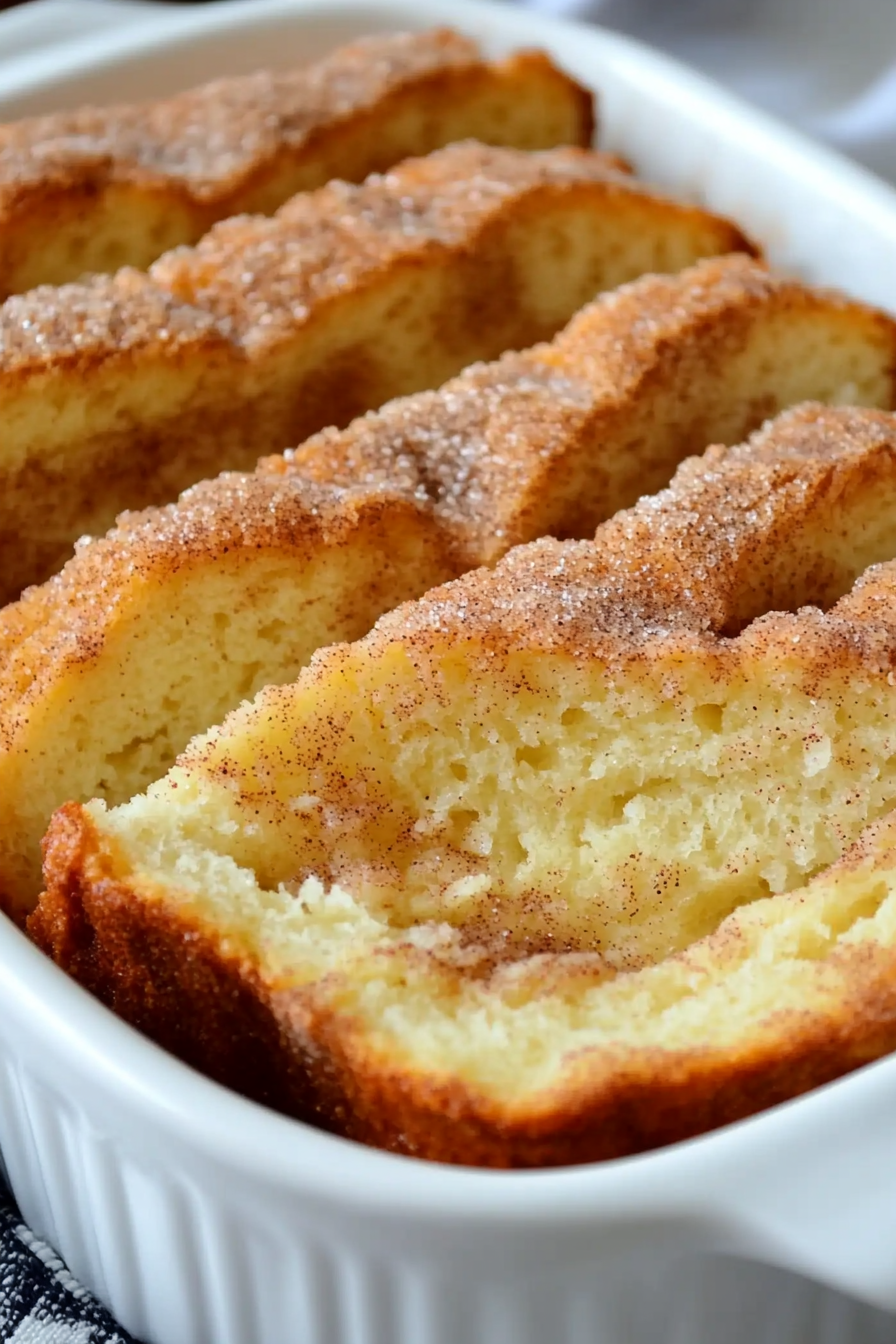 Cinnamon Swirl Cake sliced in a white baking dish, showcasing its moist texture and rich cinnamon sugar layers.