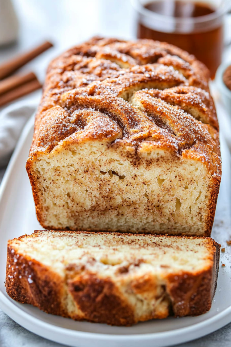 Cinnamon Swirl Cake sliced in a white baking dish, showcasing its moist texture and rich cinnamon sugar layers.