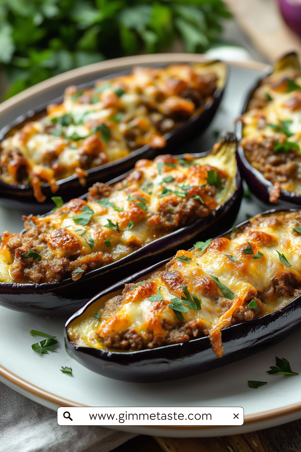 Close-up of Spanish stuffed eggplants filled with ground meat, onions, peppers, and cheese, garnished with fresh parsley.