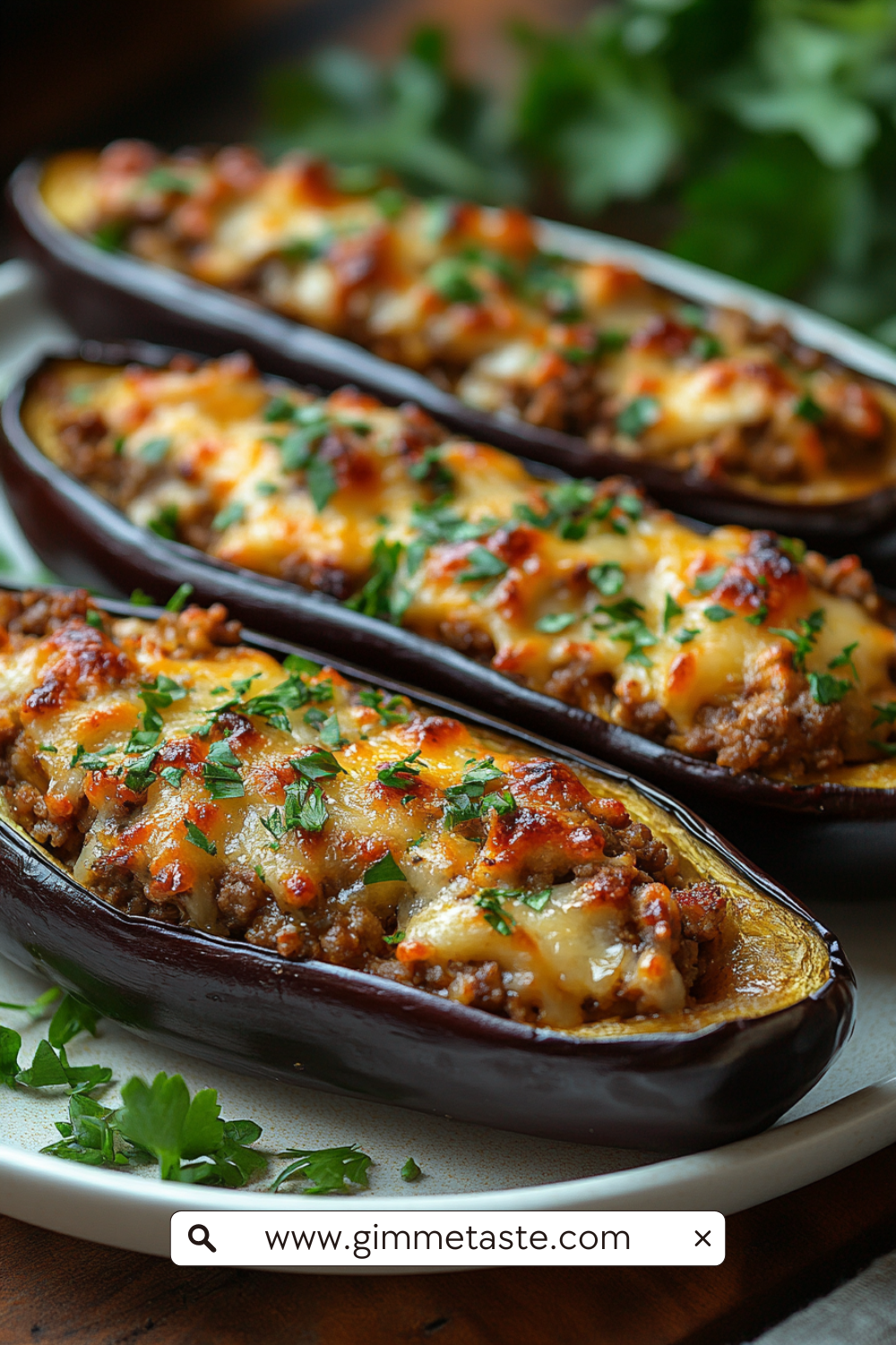 Close-up of Spanish stuffed eggplants filled with ground meat, onions, peppers, and cheese, garnished with fresh parsley.