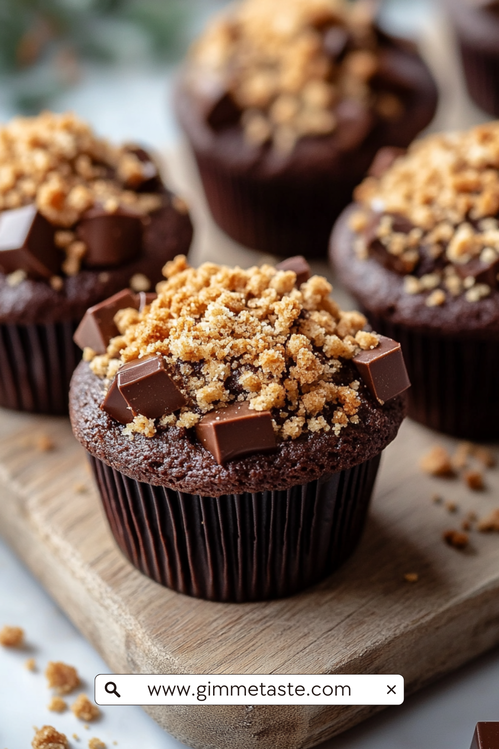 Chocolate Coffee Toffee Crunch Muffin with crumbly streusel topping on a wooden board.